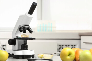 Wall Mural - microscope with slice of apple on table in laboratory, space for text. poison detection