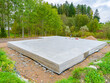 © Grispb - Concrete foundation next to trees. Construction near forest. Construction site with foundation. Foundation as a symbol of construction of a cottage. Building of a country cottage.