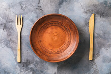 Empty Clay Plate And Wooden Cutlery, Top View. Food Background