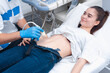 © salomonus_ - The young doctor makes an ultrasound of the abdominal cavity to a young beautiful girl. Ultrasound pregnancy
