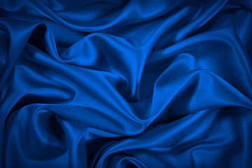 Wall Mural - Deep blue silk satin fabric. Elegant abstract background. Liquid wave effect or silk with soft wavy folds. Beautiful navy blue fabric background with copy space for your design.