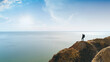 © realstock1 - The hiker standing on the mountain against the bright sun above the sea