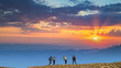 © realstock1 - The four people with backpacks walking on the mountain sunset background