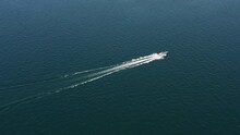 An Open-topped Large Gray Speedboat Moves Quickly On Blue Water, Aerial View. Flying Over The Boat Diagonally Top View