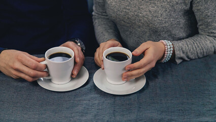 Wall Mural - Man and woman at the table with a cup of coffee. Selective focus.