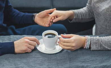 Wall Mural - Man and woman at the table with a cup of coffee. Selective focus.