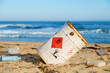 © marina_larina - Spilled trash on beach of big city. Empty used dirty plastic bottles. Toxic rusty barrel. Dirty Black Sea. Environmental pollution. Ecological problem. Toxic waste, chemical industry. Moving waves