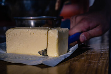 close-up of rectangular dairy butter bread for gastronomy and food preparation on glass with knife with sunlight