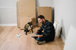 Portrait of man and his dog assembling furniture. Do it yourself furniture assembly.