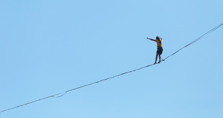 Wall Mural - A man walks along the highline against the blue sky.