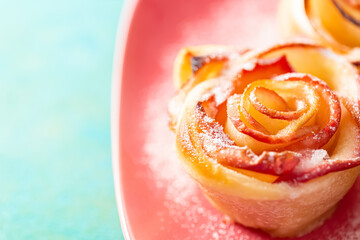 Pieces of apples baked and sprinkled with sugar. Flower with apples. Shallow depth of field. Wooden green surface.