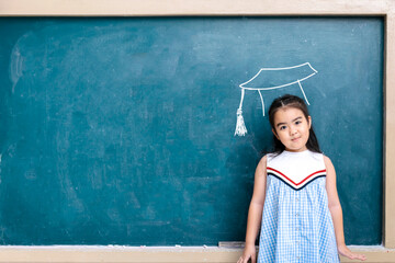 Smart educated school kid student with graduation hat doodle on chalkboard for children's education success