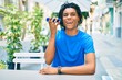 © Krakenimages.com - Young african american man smiling happy listening audio message on the smartphone at terrace.