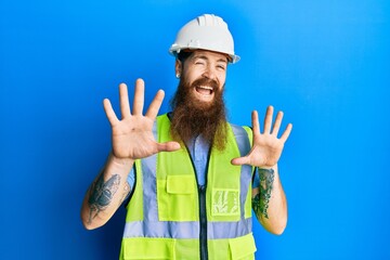 Poster - Redhead man with long beard wearing safety helmet and reflective jacket afraid and terrified with fear expression stop gesture with hands, shouting in shock. panic concept.