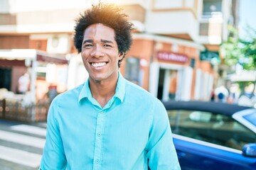 Wall Mural - Young handsome african american man wearing casual clothes smiling happy. Standing with smile on face walking at town street.