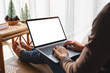 © Farknot Architect - Mockup image of a woman working and typing on laptop computer with blank white screen at home