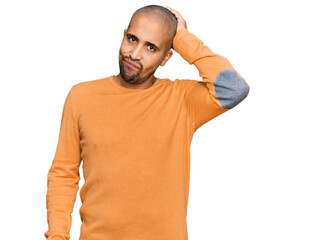 Canvas Print - Hispanic adult man wearing casual winter sweater confuse and wonder about question. uncertain with doubt, thinking with hand on head. pensive concept.