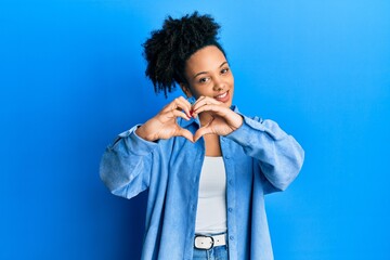 Poster - Young african american girl wearing casual clothes smiling in love doing heart symbol shape with hands. romantic concept.