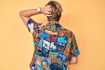 Canvas Print - Young blond man wearing summer shirt backwards thinking about doubt with hand on head