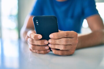 Sticker - Young irish man smiling happy using smartphone sitting on the table at home.