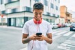 © Krakenimages.com - Young latin man smiling happy using smartphone and headphones at the city.