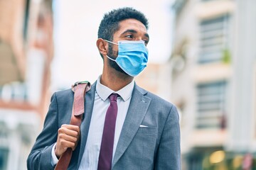 Poster - Young african american businessman wearing medical mask at the city.