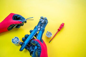 Wall Mural - Electrician peeling off insulation from wires - closeup on hands and pliers