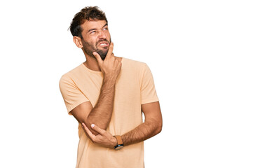 Poster - Handsome young man with beard wearing casual tshirt thinking worried about a question, concerned and nervous with hand on chin