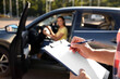 © New Africa - Instructor with clipboard near car outdoors, closeup. Driving school exam