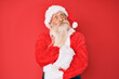 © Krakenimages.com - Old senior man with grey hair and long beard wearing traditional santa claus costume smiling looking to the side and staring away thinking.