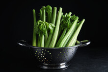 Fresh Green Celery In Colander On Black Table