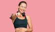 © Krakenimages.com - Beautiful blonde woman wearing gym clothes and using headphones laughing at you, pointing finger to the camera with hand over body, shame expression