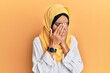 © Krakenimages.com - Young brunette arab woman wearing traditional islamic hijab scarf with sad expression covering face with hands while crying. depression concept.