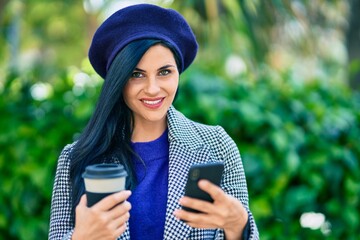 Wall Mural - Young beautiful woman wearing french style using smartphone and drinking take away coffee at the park.