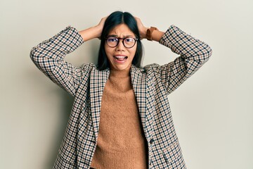 Sticker - Young chinese woman wearing business style and glasses crazy and scared with hands on head, afraid and surprised of shock with open mouth