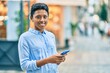 © Krakenimages.com - Young african american girl smiling happy using smartphone at the city.