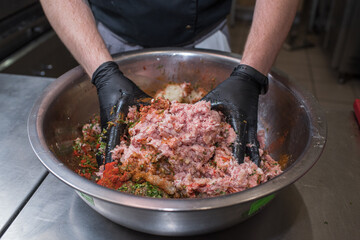 The chef mixes minced pork with different ingredients