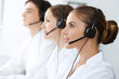 © rogerphoto - Call center. Beautiful young woman using headset and computer to help customers. Business concept