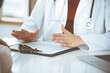 © rogerphoto - Unknown woman-doctor and patient discussing something while sitting at the table in clinic, close-up. Medicine concept