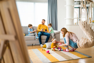 Wall Mural - Happy young family spending time together at home