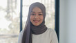 Portrait of successful beautiful executive businesswoman casual wear looking at camera and smile, happy in modern office workplace. Young Asia muslim lady stand relax in contemporary coworking space.