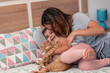 © Brian Díaz - Mother, daughter and their cat, playing on the bed at home.