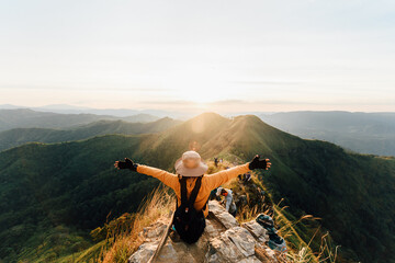 happy woman hiking and sitting on top mountain at khao chang phuak, thongphaphoom national park, kan