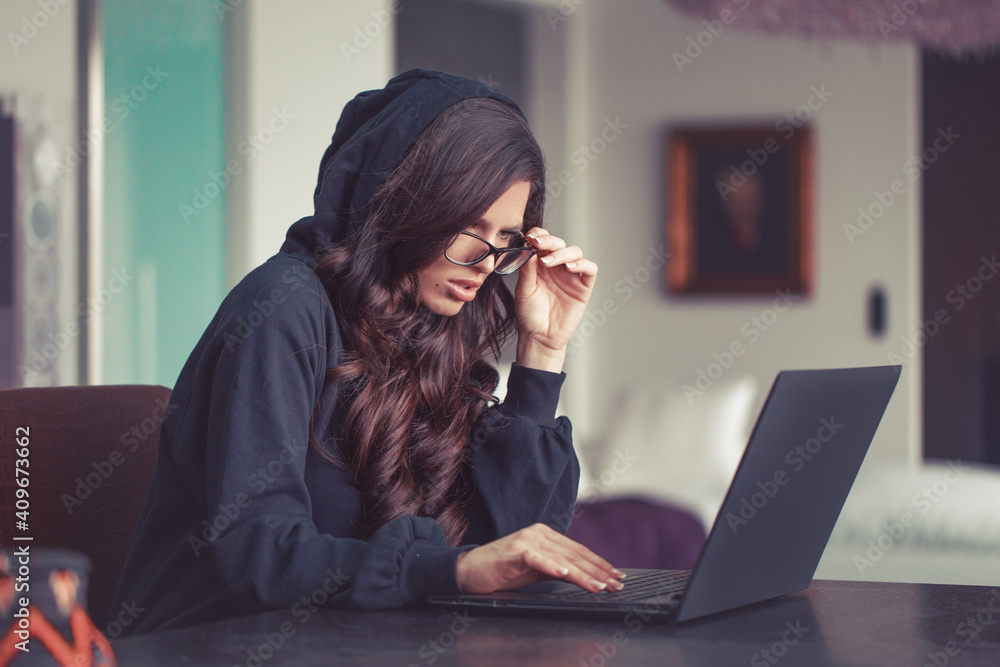Woman in hoodie seeing unbelievable thing on internet - obrazy, fototapety, plakaty 