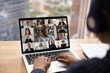 © fizkes - Over shoulder view of female in headset take part in distant virtual briefing video conference using laptop. Young woman employee meet with diverse colleagues online discuss work affairs on quarantine