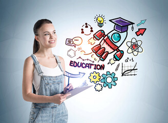 Wall Mural - Portrait of inspired young student woman in denim overalls with notebook standing in room with colorful business education sketch drawn on it. Concept of planning and business education