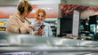 © Jacob Lund - Friendly employee helping customer at the supermarket