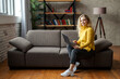 © Ankor_stock. - Beautiful young woman working from home on a laptop sitting on the sofa in the living room