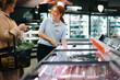 © Jacob Lund - Worker helping a customer in grocery store