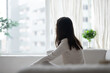 © fizkes - Pensive young woman sit alone at home look in window distance thinking pondering feeling lonely abandoned. Unhappy female loner struggle with depression or panic attacks. Health problem concept.